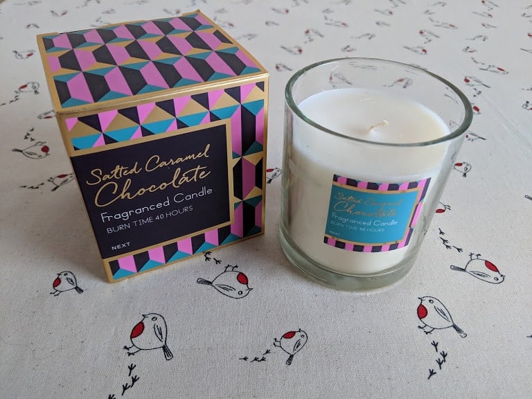 A salted caramel chocolate candle and the gift box that it comes in