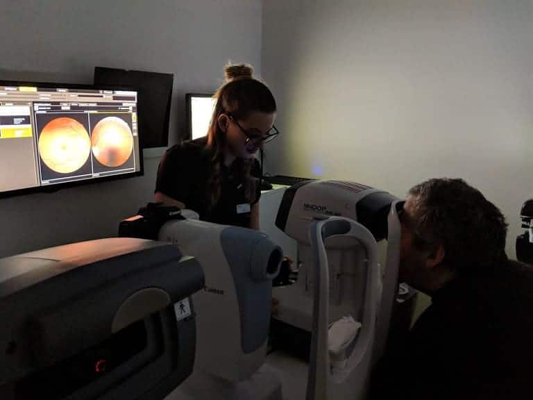 A man having an eye test with a lady optician