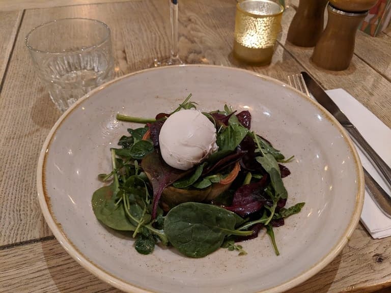 Spinach tart with lettuce leaves and a poached egg
