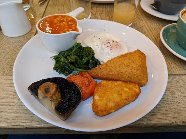 fully cooked Vegetarian english breakfast with hash browns, egg, beans, spinach and mushroom