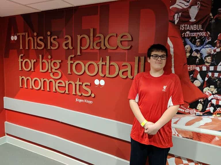 Liverpool F.C. Anfield Tour boy in front of sign.