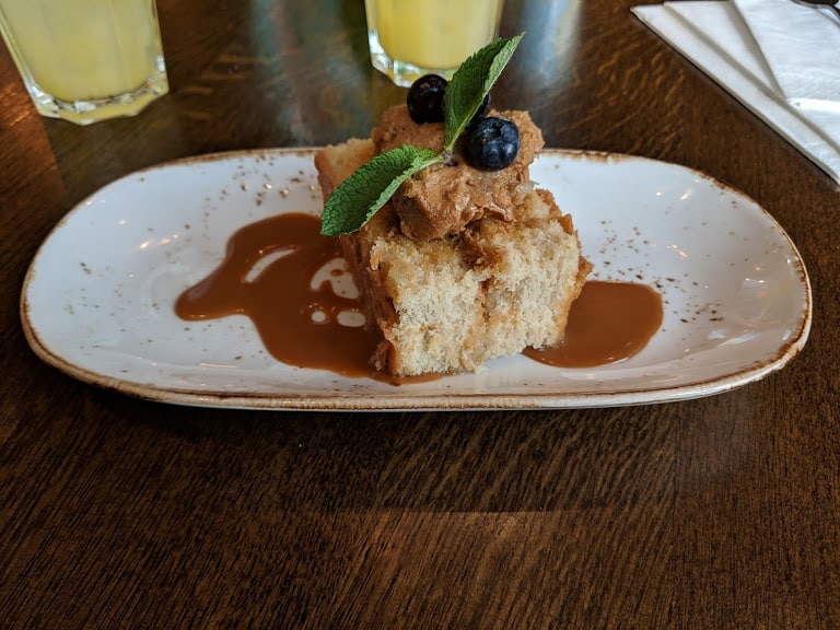 creamy caramel cake with a drizzle of caramel, topped with blueberries.