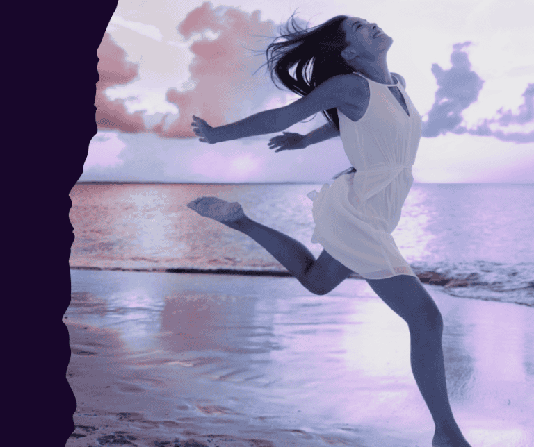 a happy woman dancing in front of the sea on sunset time