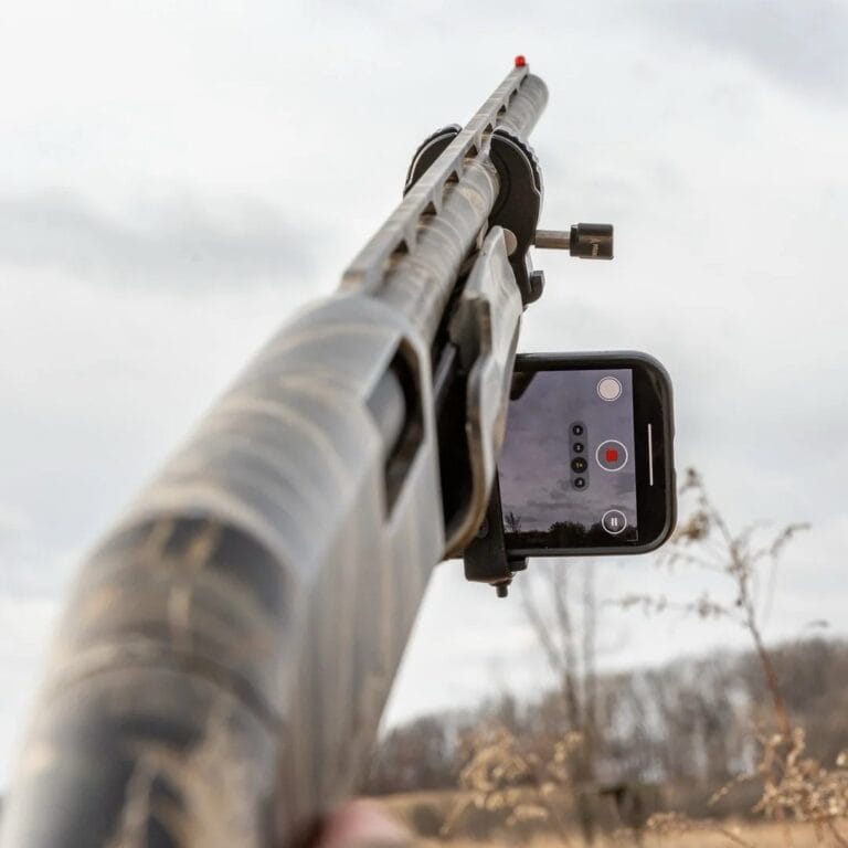 Close-up of a rifle mounted with a smartphone for recording shooting accuracy or outdoor hunting, showcasing innovative hunting gear and accessories from Hot Deals LB.