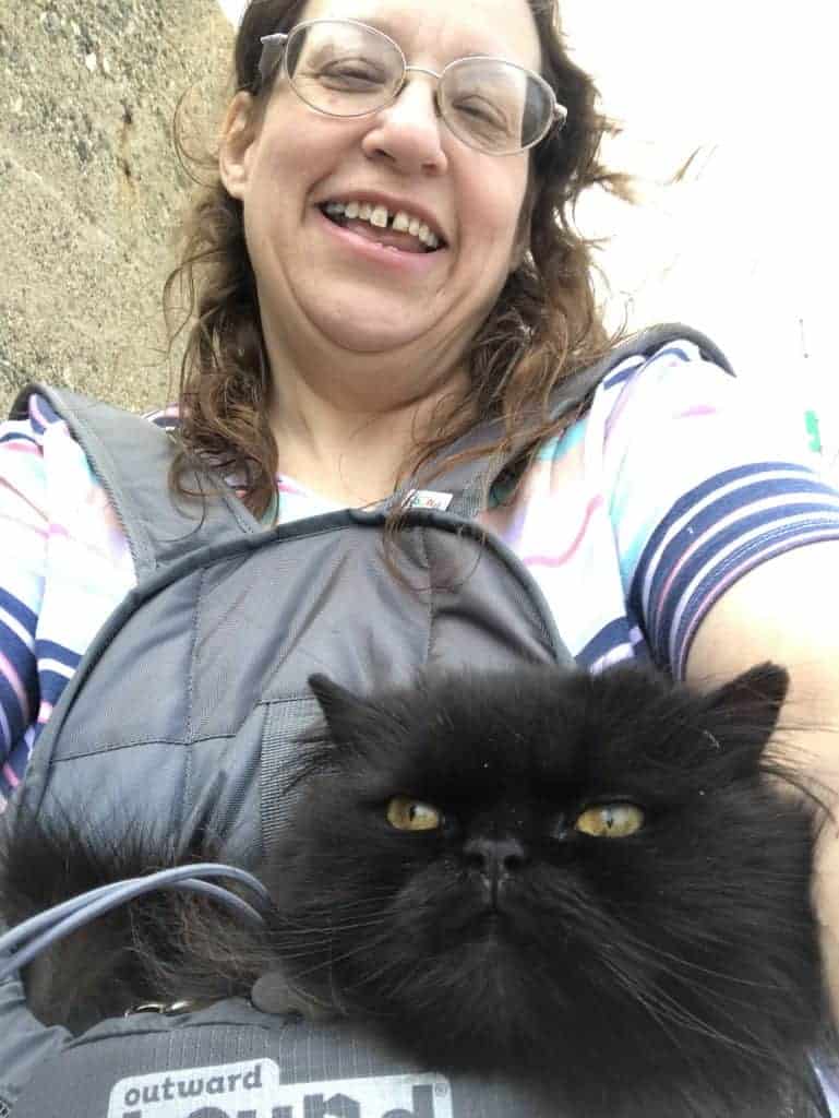 woman with a black cat in a backpack