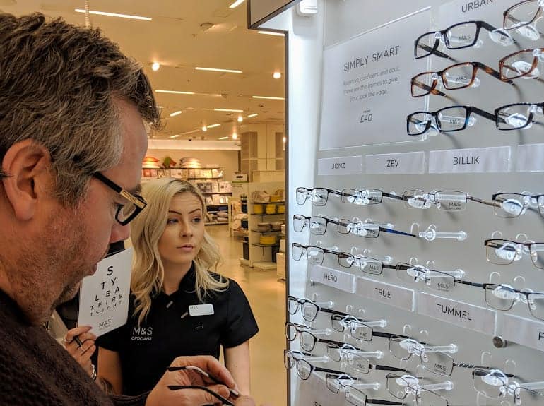 A gentleman choosing some glasses, each pair of glasses has a name to it