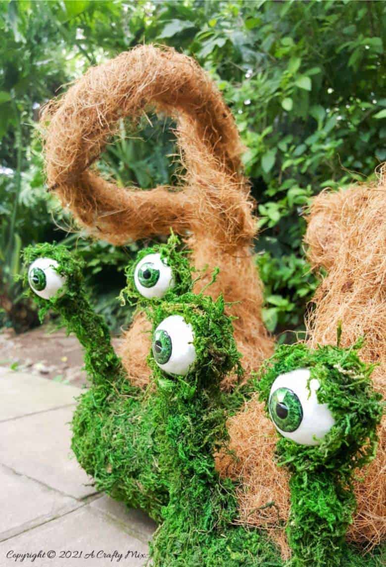 Add a little light-hearted fun to you porch décor with these easy to make mossy creatures. With bendable caps and popping eyes they’re sure to put a smile on your face. #PorchDecor #MossCreatures #ACraftyMix