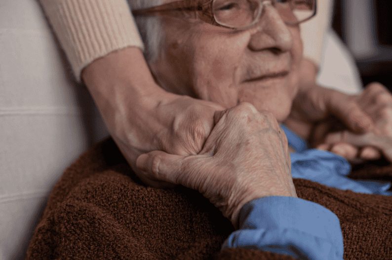 young person holds hands with dementia sufferer