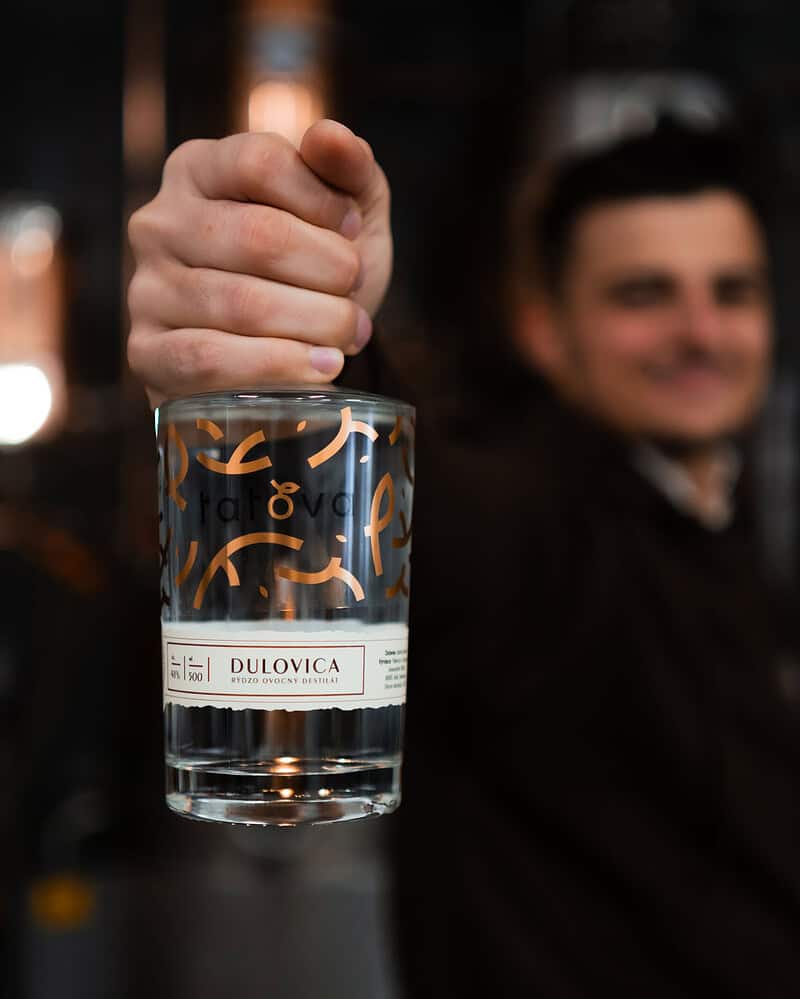 barman drziaci lahev dulovice tatova z lokalnych dul s obsahom alkoholu 48%, objem 0,5L