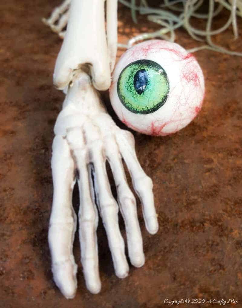 Up the creepy stakes this Halloween and make these realistic eyeballs. Quick and budget-friendly they'll add just the right spooky factor to your decor. The tutorial includes free "iris" printables to use #HalloweenDecor #CreepyEyeballs #ACraftyMix #FreePrintables