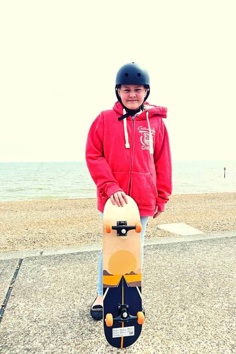 teenage girl skateboarding on concrete on the beach front.
