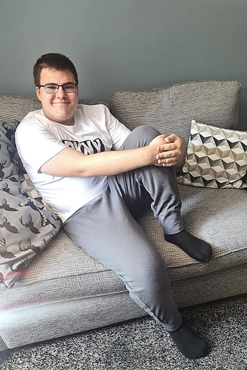 Teenage boy in dkny loungewear sitting on a sofa