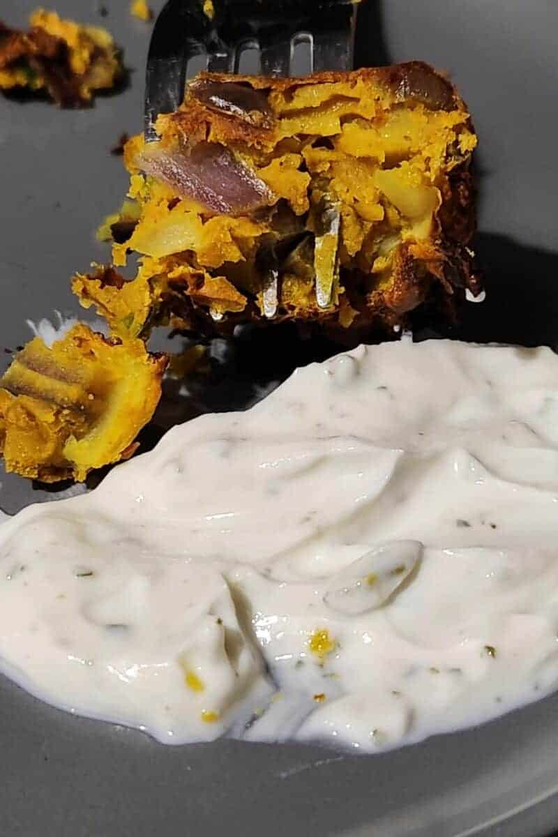 onion bhaji with yoghurt dip on a fork