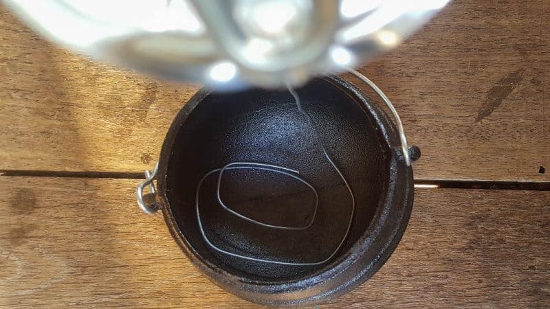 Place the twirled wire inside a pot and weigh down with a large pebble