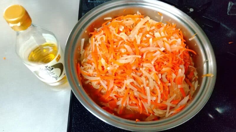 フライパンで炒めた大根と人参とツナに酢を投入