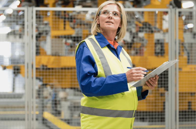 Pregnant worker in warehouse with safety vest