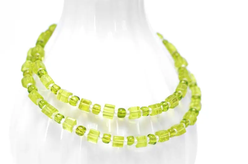 Kurze Halskette mit limettengrünen Glasperlen auf weißem Hintergrund
