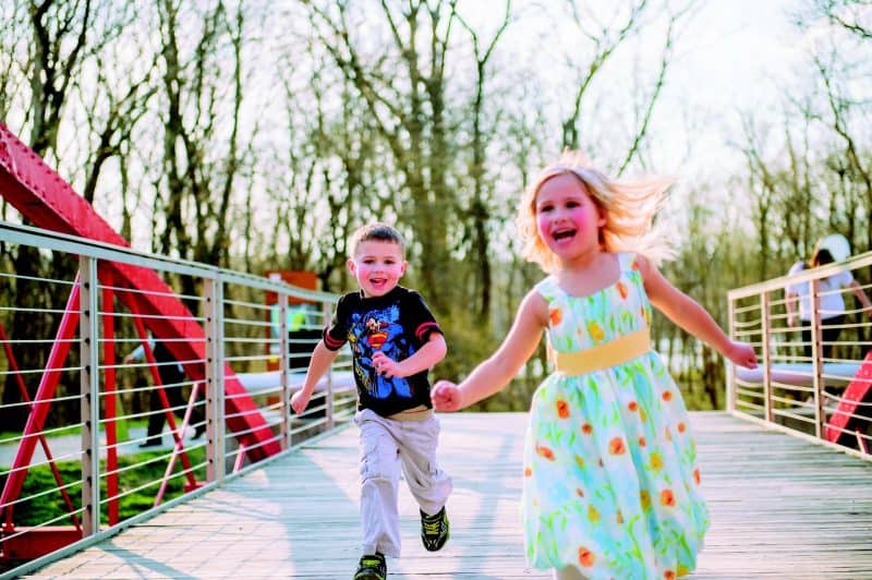 Dos niños corriendo por un puente