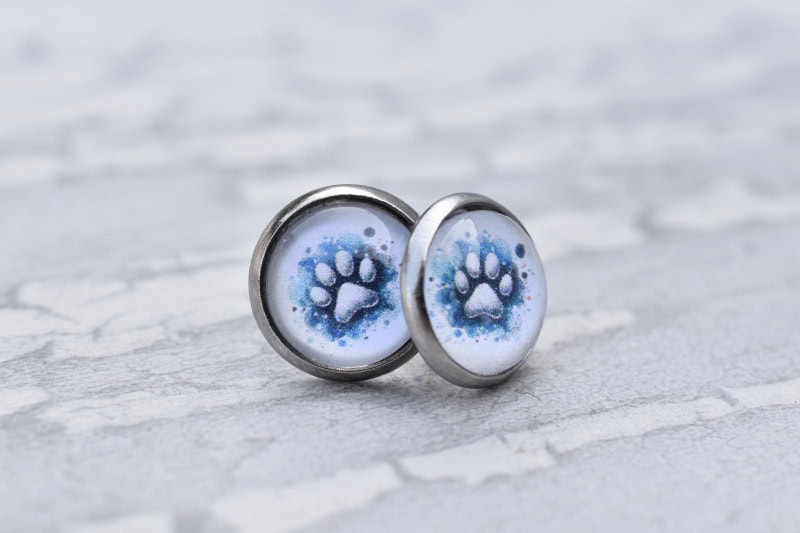 Edelstahl Ohrstecker mit blauem Pfotenmotiv. Symbolischer Erinnerungsschmuck.