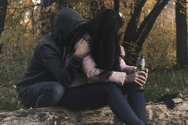 Jóvenes sentados con una botella verde