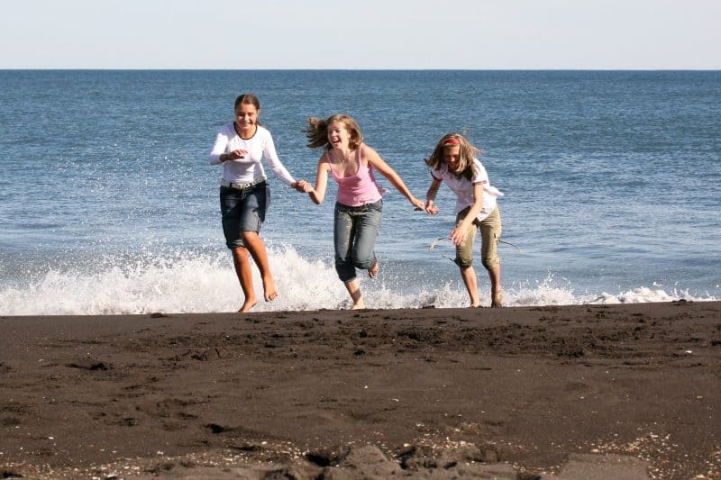 Adolescentes jugando y riendo en la playa
