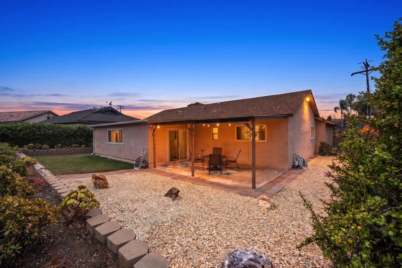 Backyard patio with a covered concrete area, gravel landscaping, and a small grassy section at 5237 Diane Ave in Clairemont.