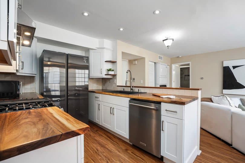 Kitchen with white cabinetry, wood countertops, stainless steel appliances, and a view extending into the living room at 205 Ohio St Unit 304 in North Park.