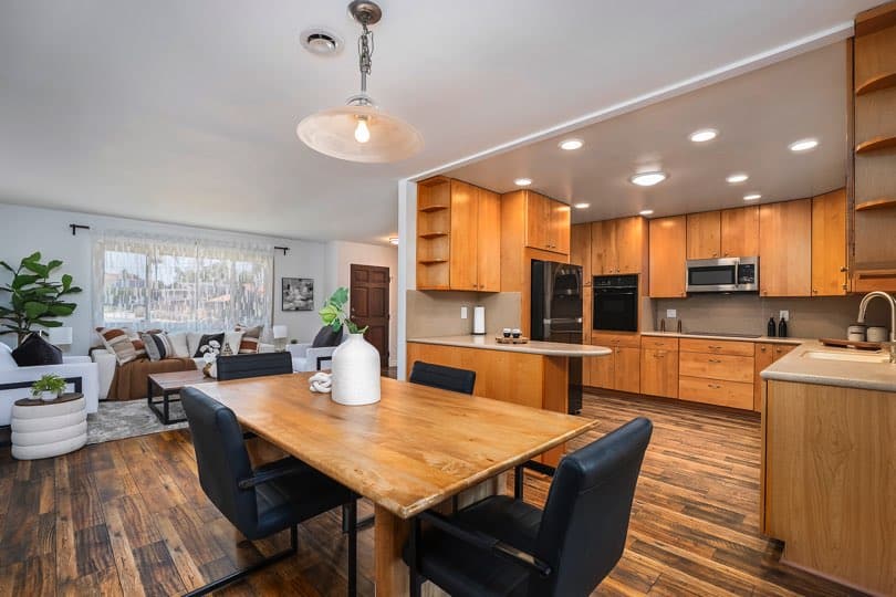 Open-concept kitchen with light wood cabinetry and a wooden dining table featuring four black chairs at 5237 Diane Ave in Clairemont.