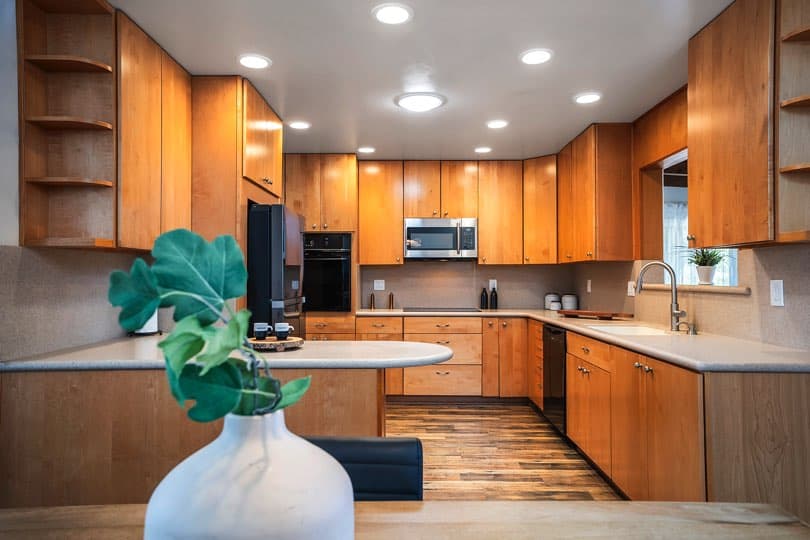 Open-concept kitchen with light wood cabinetry and a wooden dining table featuring four black chairs at 5237 Diane Ave in Clairemont.
