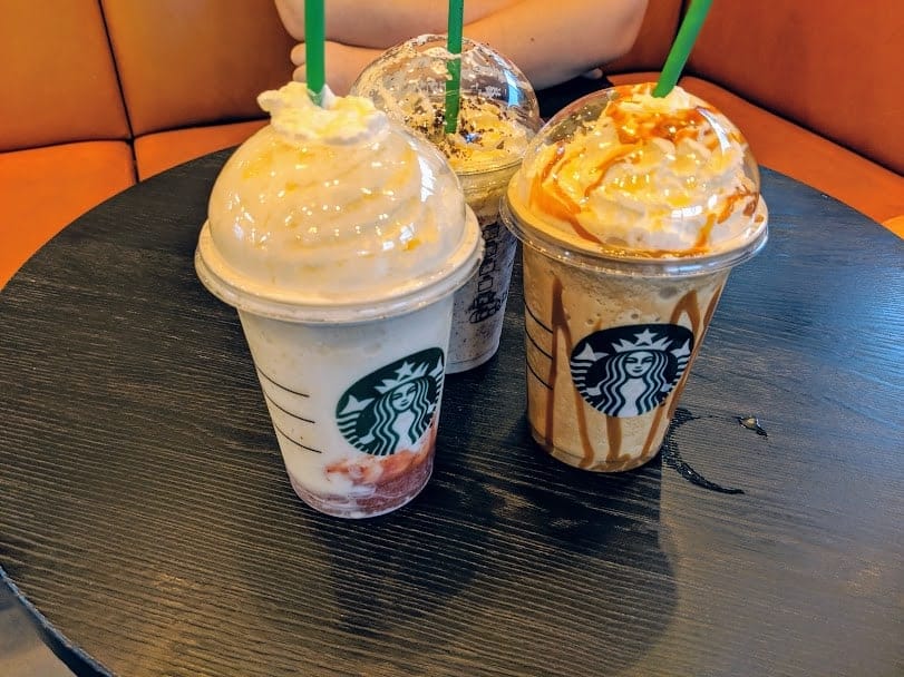 Starbucks Frappaccinos on a wooden table.