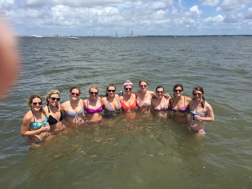 Group of women taking a group picture together in the water. Charleston booze cruise bachelorette