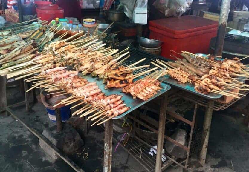 Kep Crab Market in Kep, Cambodia Kep Crab Market in Kep, Cambodia. Mountains of skewers of squid, prawns and other seafood on tables with a red esky coolbox in the background.