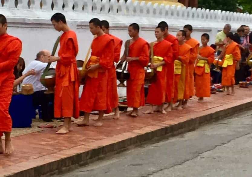 Tak Bat Alms Giving in Luang Prabang, Laos Monks in orange robes at Tak Bat alms giving in Luang Prabang