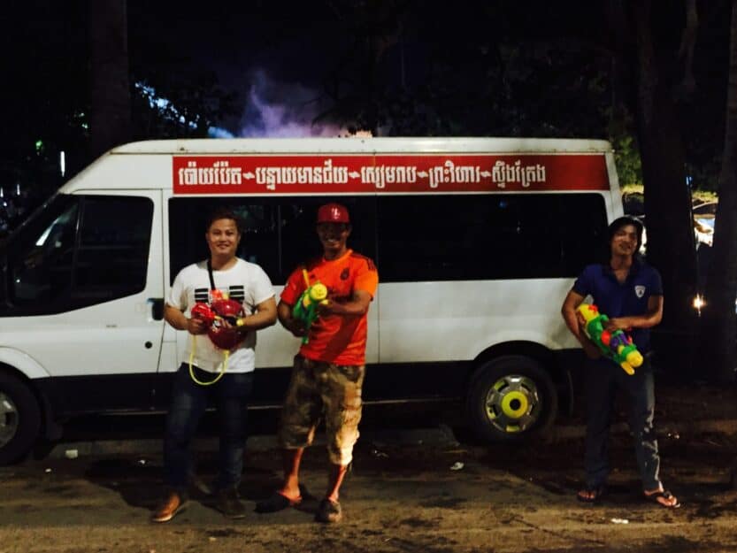 Water Fights Khmer New Year in Siem Reap Cambodia Three locals standing in front of a white van with water guns during Khmer New Year water fights in Siem Reap