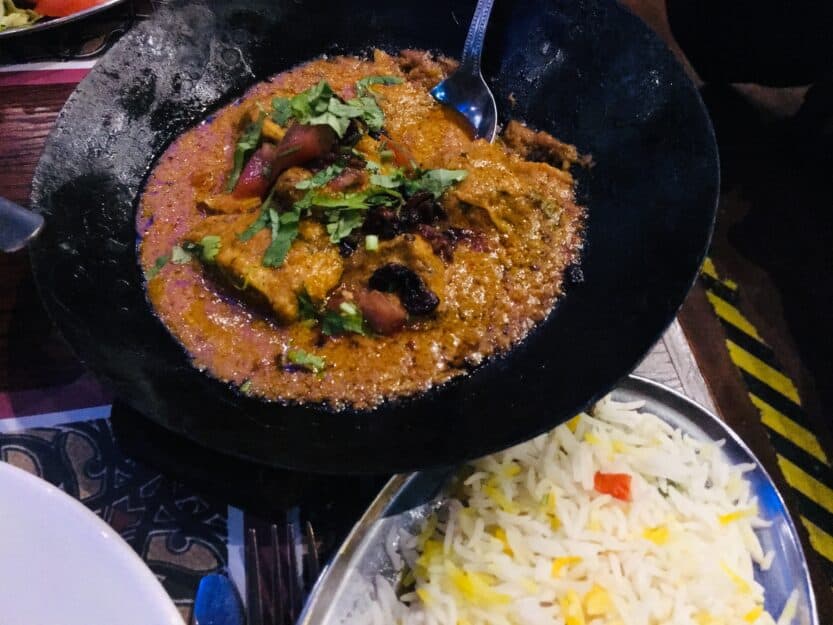 Curry at Tayyabs Tomato based curry in black iron dish at Tayyabs