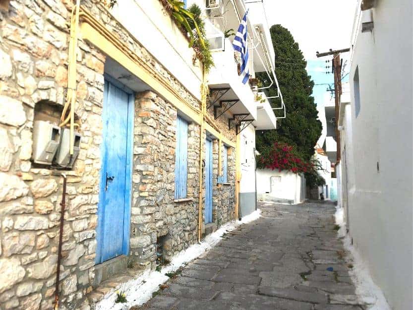 Cobbled Street in Ermioni Town Cobbled back street of Ermioni town. To the left a stone house with blue doors and shutters.