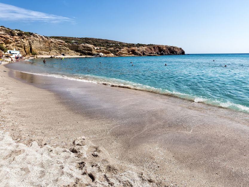 Firiplaka Beach on Milos in Greece. Firiplaka Beach on Milos in Greece. Fie sand beach on the left curving gently towards rocks at the end of the bay with blue sea to the right.