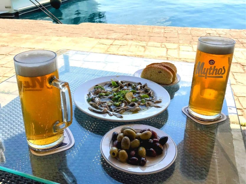 Millenium Cafe Bar in Ermioni Greek beer and meze on the table outside Millenium Cafe Bar in Erminoi. Blue sea in the background.