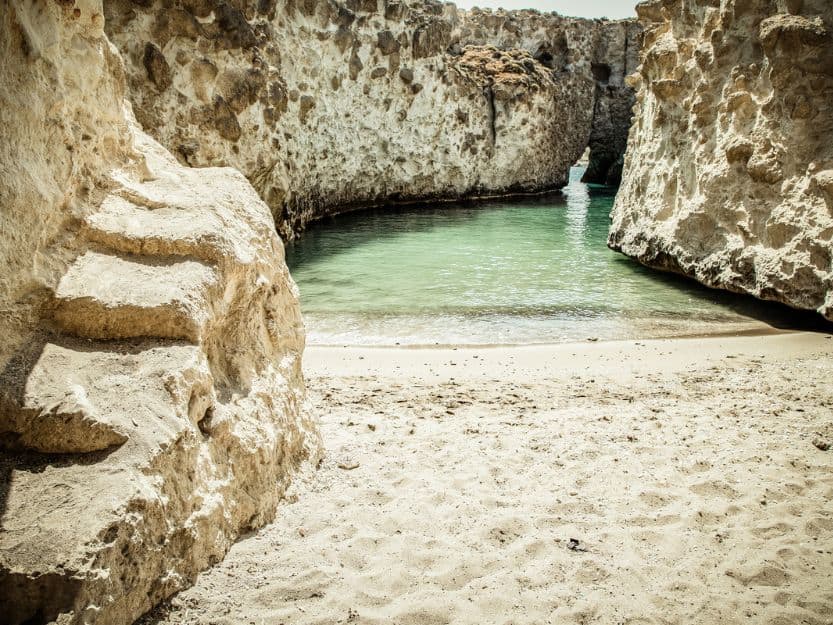 Papafragas Cave Beach Papafragas Cave Beach on Milos in Greece. Sheltered pool with small sandy beach, that opens up into the sea through a natural arch.