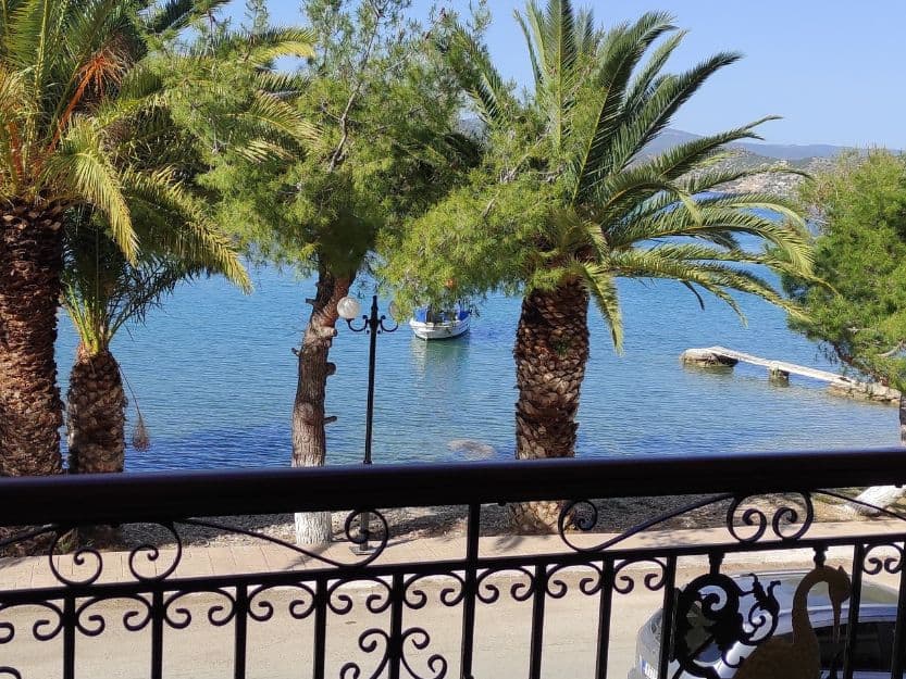 Balcony View at Philoxenia Ganossis in Ermioni. Balcony view at Philoxenia Ganossis in Ermioni. Overlooking the blue sea with palm trees in front.
