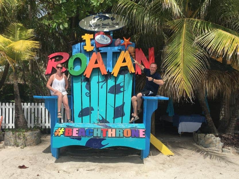 Colourful Wooden Beach Throne on Roatan Island in Honduras Tanya and Andy sitting on colourful wooden beach throne on Roatan Island in Honduras