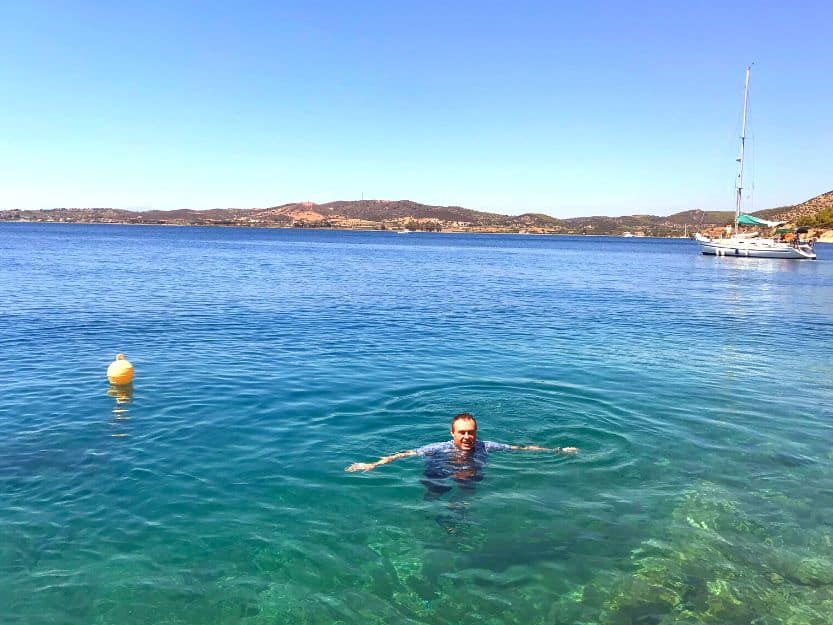 Swimming in Ermioni in Greece. Andrew swimming in the crystal blue sea on Mandrakia side of Ermioni in Greece. He is wearing a light blue shirt so he doesn't get sunburnt