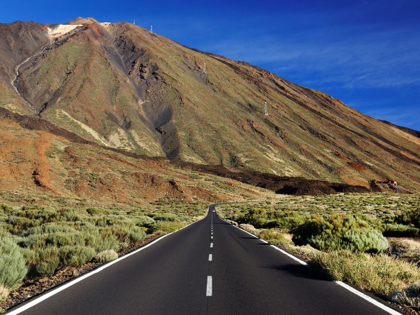Teide National Park, Tenerife Teide National Park, Tenerife. Imag of road leading to Mount Teide with blue sky in background.