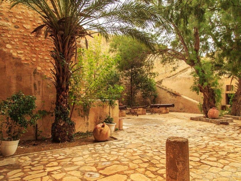 Palm tree filled stone courtyard in the Kasbah in Hammamet