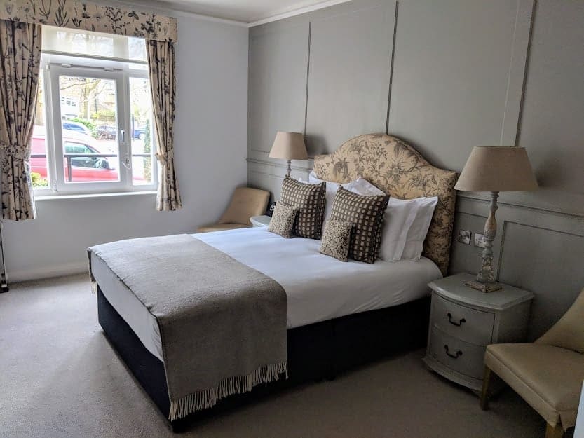 A bedroom with a bed and desk in a room
