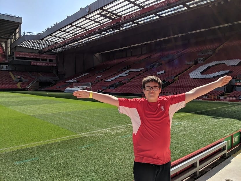 Boy on the Liverpool F.C. Anfield Tour standing in front of the pitch.