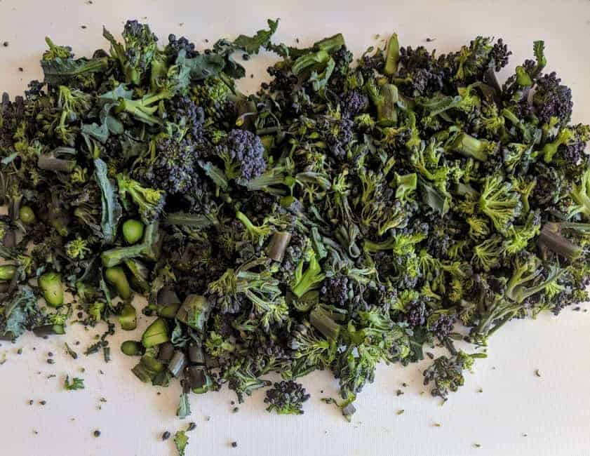 finely chopped broccoli on marble chopping board