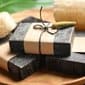 black cumin soap bars wrapped with brown paper on a wooden plate