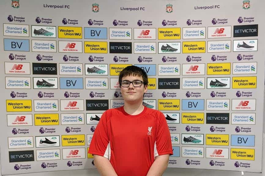 Boy standing in front of football interview board.
