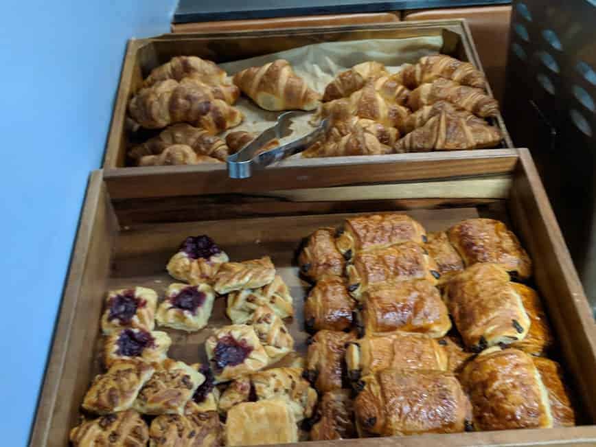 A box filled with different breakfast foods including pain au chocolats and croissants